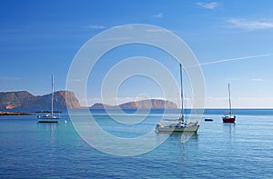 Sailboat docked in front of the beach and the port of Es Canar, Ibiza Island photo