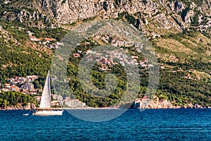 Sailboat floating on the Adriatic Sea in Montenegro. Saint Setafan Island in the background