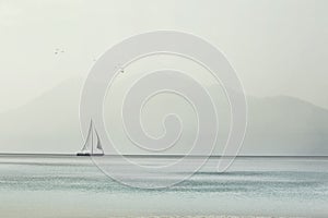 Sailboat glides lightly on the waves of a spectacular ocean