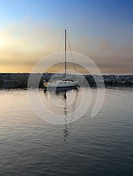 Sailboat in harbor at sundown