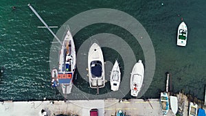 Sailboat harbor. Yachts and small fishing boats in the sea port. Aerial drone view.