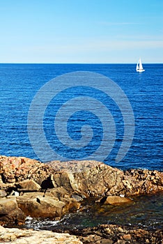 A sailboat heads towards the open ocean