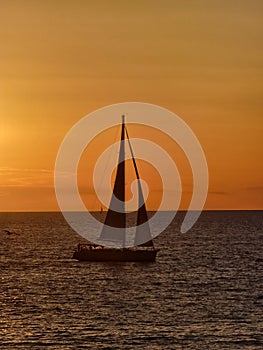 Sailboat on the ionic sea at sunset