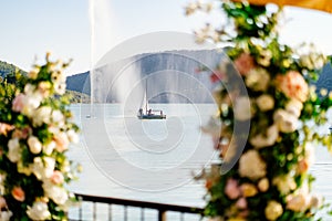 Sailboat on lake at fountain through ruck flowers