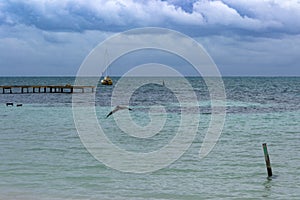 A sailboat lies at anchor off the coast of Caye Caulker, Belize.