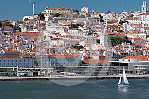 Sailboat on Lisboa Tagus River, waterfront and cityscape. Vacation, leisure, travel concept.