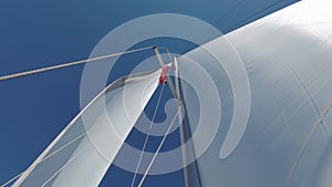 Sailboat Mast and Sail. Open, unfurled sails on a yacht. Sailing in the wind