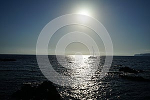 Sailboat on the Mediterranean Sea in the rays of the setting sun. Cirkewwa, Mellieha, Malta