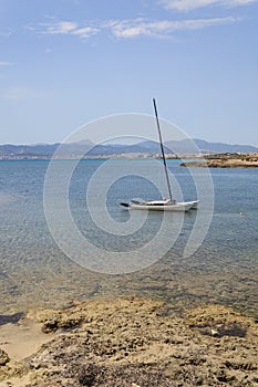 Sailboat moored in shallow water Cala Estancia