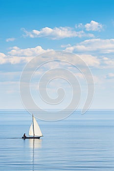 Sailboat navigating open waters under blue sky