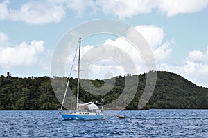 Sailboat on the ocean with a beautiful blue sky and puffy white cloud background