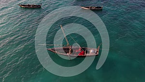 Sailboat in the ocean. Sunset. Drone view of the african traditional wooden boats. Sailing yachts moored off the coast