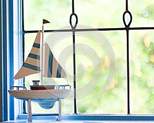 Sailboat ornament in front of lead light window