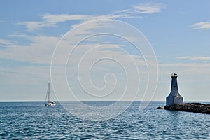 Sailboat passing by Cobourg East Pierhead Lighthouse