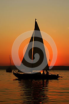 Sailboat with people in sunset