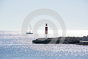 Sailboat and pier with inlet on a bright sunny day