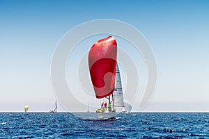 Sailboat with red gennaker competing during regatta