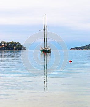Sailboat reflected on sea at Porto Heli beach Argolis Greece
