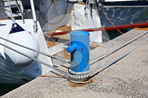 Sailboat ropes tied to marina bollard