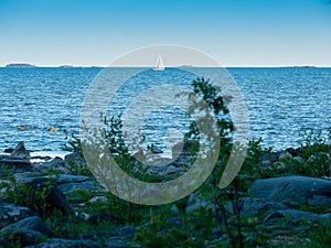 A sailboat sailing across the horizon during sunset