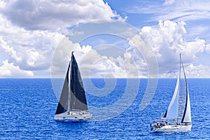 Sailboat sailing on the beach in Mallorca under a blue sky with white clouds