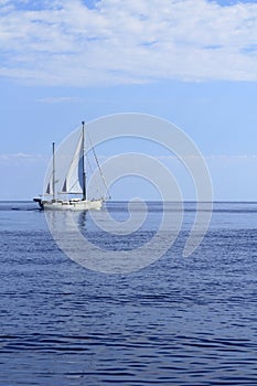 Sailboat sailing on blue sea horizon ocean