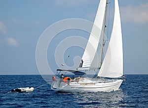 Sailboat sailing with dinghy