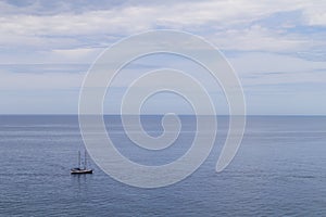 Sailboat sailing in the morning with blue cloudy sky. Luxury yacht in open waters with beautiful clouds