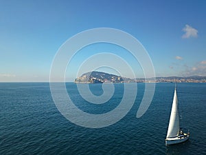 Sailboat sailng at sea with coastline