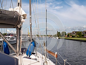 Sailboat with sails down motoring in Lemmer canal, Friesland, Netherlands