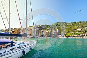 A sailboat sails into the harbor at the colorful village of Porto Venere on the Ligurian coast of Italy at La Spezia