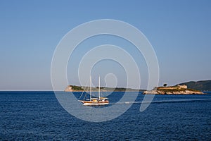 Sailboat sails past the Mamula island. Montenegro