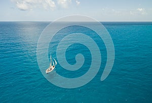 Sailboat in Bright Blue Water - Aerial View - Isla Mujeres, Mexico photo