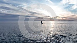 Sailboat in the sea in the sunlight, luxury summer adventure, active vacation in ocean. Sail boat on ocean waves.