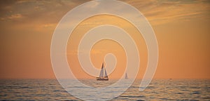 Sailboat in the sea. Sunrise over the sea and beautiful cloudscape. Colorful ocean beach sunset.