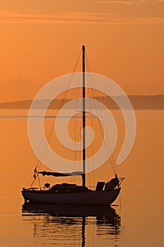 Sailboat silhouette during orange sunrise