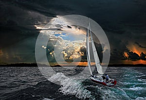 A sailboat in the stormy sea.Black background.