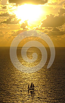 Sailboat at sunset with sun and clouds on the coast of Gipuzkoa, Euskadi