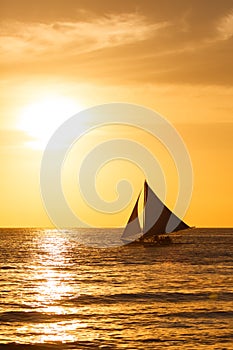Sailboat at sunset on a tropical sea. Silhouette photo.