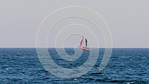 Sailboat with touristen in far away in a mediterranean sea, near town Palamos in Costa Brava