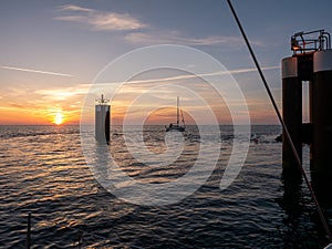 Sailboat on Waddensea leaving harbor of Hornum at sunrise, Sylt island, North Frisia, Germany