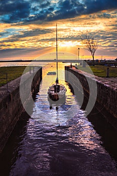 Sailboat between the walls at beautiful colorful sunrise at Claddagh, Galway, Ireland