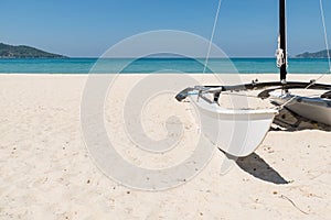 Sailboat on white sand beach in summer clear blue sky