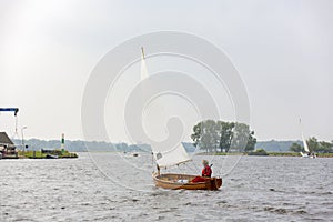 A sailboat with a woman sailing on the Kaag