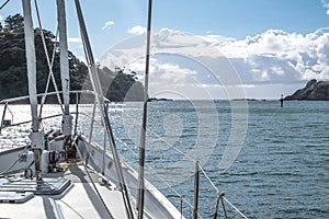 Sailboat yacht motoring out of Tutukaka Harbour between rocks an