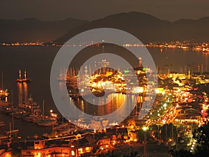 Sailboats anchored in harbor night scene