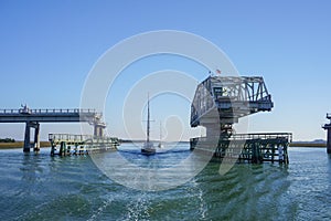 Sailboats cruising through an open swing bridge on the ICW photo