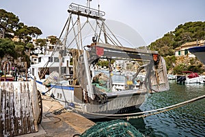 Sailboats with equipment moored on sea at harbor in city against clear blue sky