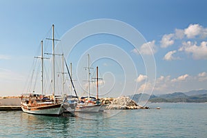 Sailboats on pier. Calm sea water and blue sky background