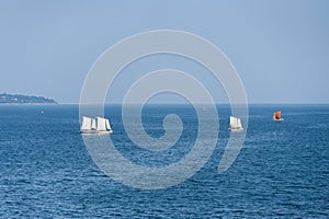Sailboats sailing on deep blue ocean